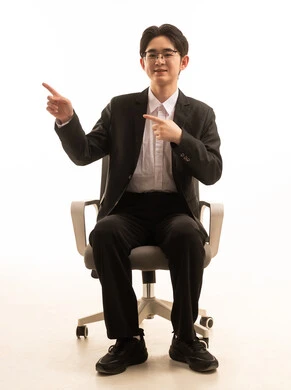 A portrait of an Asian man wearing a formal suit sitting on a comfortable chair, pointing with his hands to something, a gesture indicating a specific location, a movement that signifies this place (here), with a white background. A portrait of an Asian man wearing a formal suit sitting on a comfortable chair, pointing with his hands to something, a gesture indicating a specific location, a movement that signifies this place (here), with a white background.