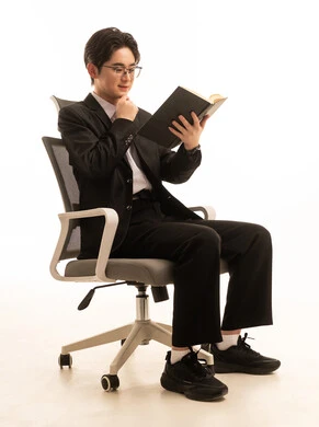 ممارسة هواية المطالعة, مفهوم الشغف بالقراءة، ثقافة التعلم الذاتى، بورتريه لرجل اسيوى يرتدي البدلة الرسمية يجلس على كرسى يحمل الكتاب، خلفية بيضاء