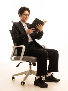 ثقافة التعلم الذاتى، بورتريه لرجل اسيوى يرتدي البدلة الرسمية يجلس على كرسى يحمل الكتاب ، هواية حب المطالعة و القراءة، خلفية بيضاء