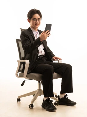 استخدام جهاز تقنى حديث، إرسال الرسائل النصية والصوتية عبر الجوال، بورتريه لرجل اسيوى يرتدى البدلة الرسمية يجلس على كرسي مريح يمسك الهاتف المحمول بتعابير السعادة, خلفية بيضاء