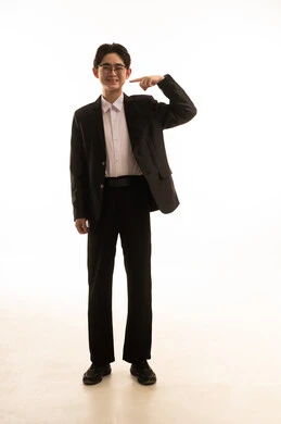 ايماءاة تحديد موقع معين، حركة تدل على هذا المكان (هنا)، بورتريه لرجل اسيوى يرتدى البدلة الرسمية ويشير باصبع السبابة الى شيء ما، صورة الجسم بالطول الكامل، خلفية بيضاء
