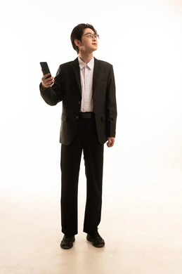 A portrait of an Asian man wearing a formal suit holding a mobile phone looking at something, browsing the internet on his mobile phone, using advanced technological devices, a full-body image, white background.