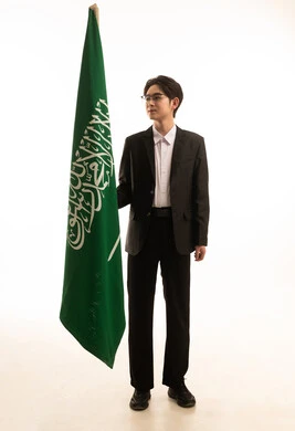 يوم العلم 11 مارس, إحياء ذكرى اليوم الوطني السعودي 23 سبتمبر, بورتريه لرجل اسيوى يرتدي البدلة الرسمية يحمل بيده علم المملكة، الجسم بالطول الكامل، خلفية بيضاء