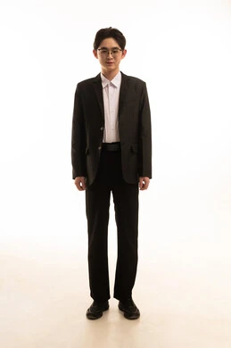 The concept of masculinity, strength, and self-confidence, a portrait of an Asian man wearing a formal suit looking at the camera with gestures of joy and happiness, attention and elegance in external appearance, white background.