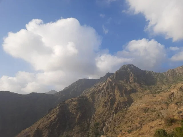 منظر طبيعي متميز للجبل في منطقة الباحة في المملكة العربية السعودية، الاهتمام بزراعة أشجار النخيل الخضراء في قرية الرخام في ذي عين الأثرية, التكوين والتشكيل الصخري للمرتفع الجبلي, معلم سياحي مشهور، مكان جذب واستقطاب السائحين