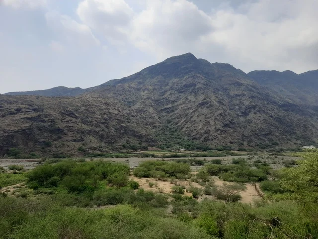 منظر طبيعي متميز للجبل في منطقة الباحة في المملكة العربية السعودية، الاهتمام بزراعة أشجار النخيل الخضراء في قرية الرخام في ذي عين الأثرية, التكوين والتشكيل الصخري للمرتفع الجبلي, معلم سياحي مشهور، مكان جذب واستقطاب السائحين