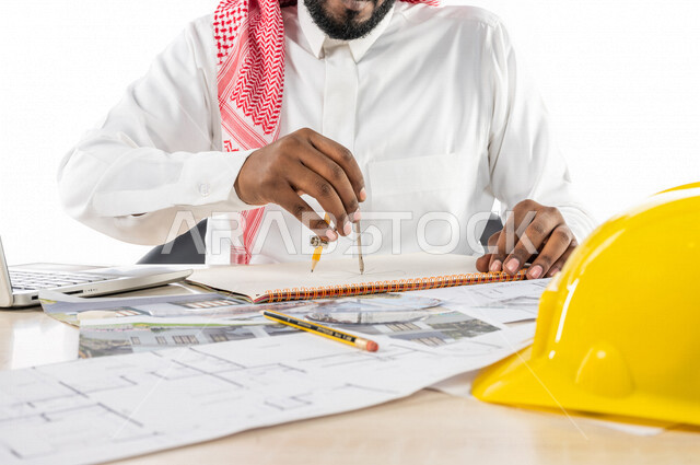 Portrait of a Saudi Gulf engineer inside an engineering office, using a laptop computer to accomplish and track tasks, protective helmet, using engineering tools and equipment on an engineering design scheme, engineering professions and jobs, white backgr
