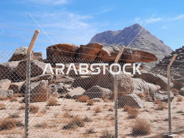 Barbed wire around the archaeological site, safari trips and fun recreational activities in Al-Ula, tourist attractions in the desert areas of the Kingdom, rock formations and structures in the middle of the Saudi desert, ancient historical archaeological landmarks, dry herbs in the desert areas.