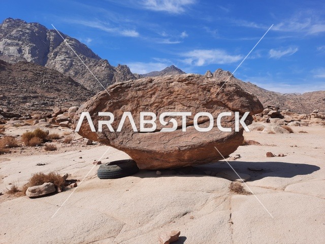 صخرة كبيرة وسط الصحراء، الاعشاب الجافة في المناطق الصحراوية، رحلات السفاري والأنشطة الترفيهية الممتعة في مدائن صالح، الأماكن السياحية في المناطق الصحراوية في المملكة، التشكيلات و التكوينات الصخرية في وسط صحراء السعودية، المعالم الأثرية التاريخية القديمة