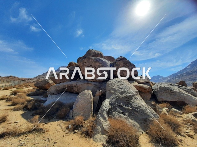 صخور كبيرة بازلتية على شكل جبل، رحلات السفاري والأنشطة الترفيهية الممتعة في مدائن صالح، الأماكن السياحية في المناطق الصحراوية في المملكة، التشكيلات و التكوينات الصخرية في وسط صحراء السعودية، المعالم الأثرية التاريخية القديمة، الاعشاب الجافة في المناطق الصحراوية