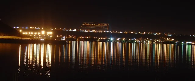 انعكاس الاضاءة الملونة على مياه البحر، ساحل البحر الاحمر في تبوك شمال المملكة العربية السعودية ، كورنيش ساحل خليج العقبة المضاء في وقت الليل، مناطق سياحية لقضاء وقت ممتع