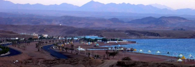 اماكن التنزه والاستجمام في الصيف، ساحل البحر الاحمر في تبوك شمال المملكة العربية السعودية ، كورنيش ساحل خليج العقبة المضاء في وقت النهار، مناطق سياحية لقضاء وقت ممتع