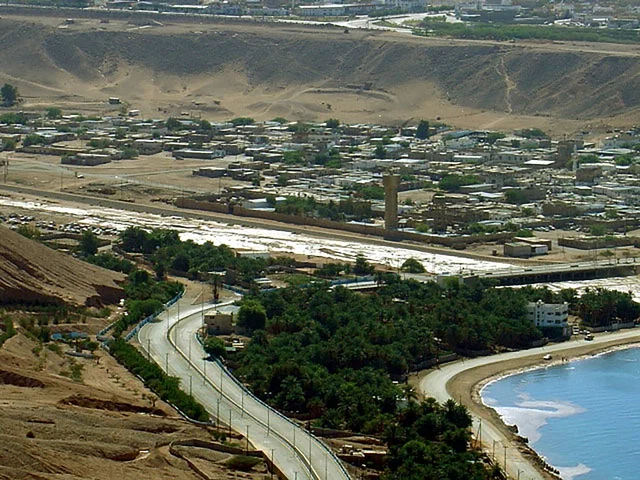 الاماكن و المعالم السياحية المشهورة في السعودية على كورنيش مدينة تبوك، النمو والتطور العمراني ،أشجار النخيل الخضراء على الواجهة البحرية ،أمواج البحر الهادئة على الشاطئ، تصريف مياه السيول عبر الوادي الى البحر