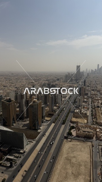 Residential and commercial buildings in the capital, urban progress and development in Saudi Arabia, King Fahd Road at sunset, the interest in planting green palm trees, the architectural engineering art of the Kingdom Tower building in Riyadh, famous tourist attractions.