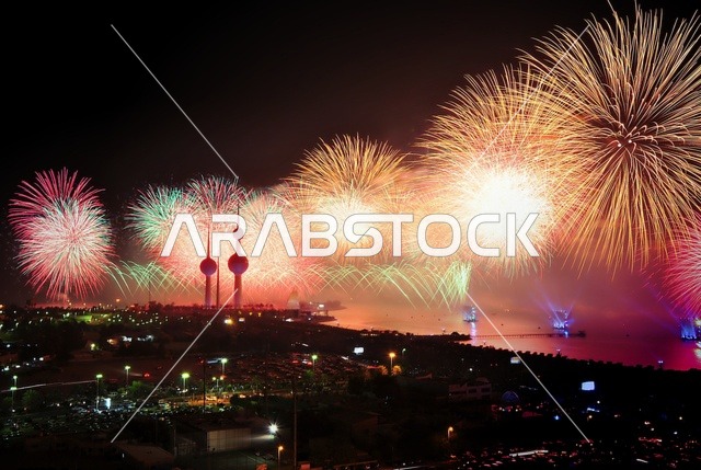المفرقعات النارية والالعاب فوق سماء الكويت، الفن الهندسي المعماري لابراج مدينة الكويت, ناطحات السحاب والمنشآت على ساحل الخليج العربي في منطقة رأس عجوزة, التطور والتقدم العمراني على الطراز الحديث والمتطور, الأشجار والنباتات الخضراء ، مقصد الزوار من أنحاء العالم