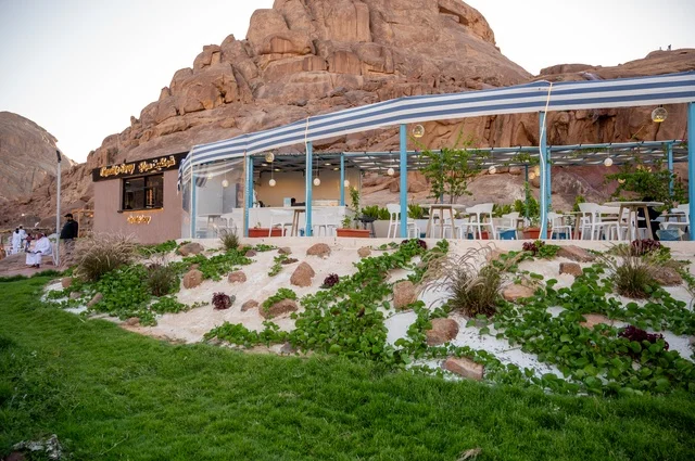 نسيم الجبال البارد، منطقة جلوس خارجية في مقهى بقرية عقدة، طابع ريفي وسط الجبال وأشجار النخيل،تجربة تجمع بين الراحة والهدوء والطبيعة في أحد مواقع ومعالم السياحة فى مدينة حائل بالمملكة العربية السعودية