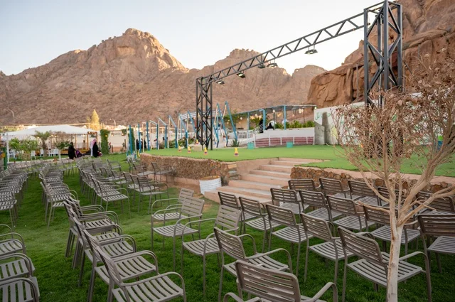 تجربة تجمع بين الراحة والهدوء والطبيعة في أحد مواقع ومعالم السياحة فى مدينة حائل بالمملكة العربية السعودية، منطقة جلوس خارجية في مقهى بقرية عقدة، طابع ريفي وسط الجبال وأشجار النخيل، نسيم الجبال البارد