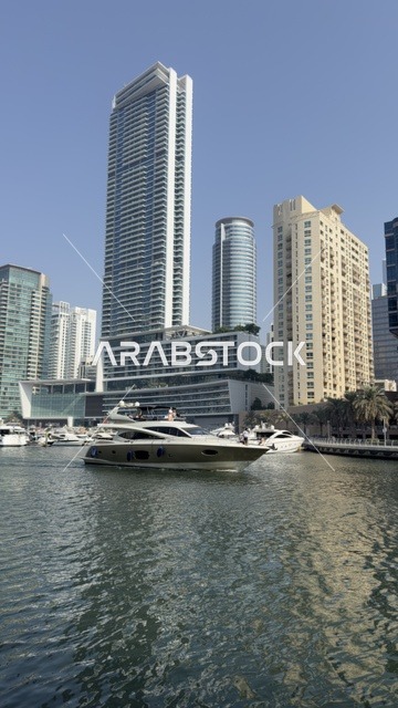 The waterfront of the Emirate of Dubai during the day, the towers and skyscrapers, the advanced and developed architectural engineering of commercial and residential establishments, famous tourist attractions in the United Arab Emirates.