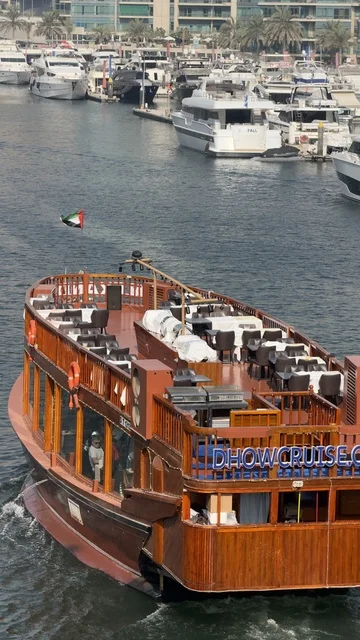 سفينة تبحر فى الواجهه البحرية لإمارة دبي في النهار، الأبراج وناطحات السحاب ، الفن الهندسي المعماري المتطور والمتقدم للمنشآت التجارية والسكنية، معالم سياحية مشهورة في الإمارات العربية المتحدة