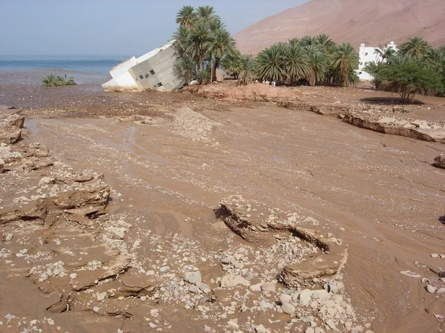 A depiction of a house collapse in the city of Tabuk, floodwaters from rain in the Haql governorate in the Kingdom of Saudi Arabia, landmarks of Tabuk, natural scenery.