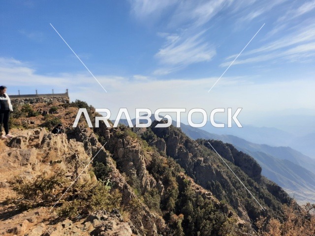 An aerial image of the mountainous environment, plateaus, and highlands, a view of the sky above the landscapes in Al-Soudah Park, the grasses, trees, and green plants in the Soudah Mountains in the Asir region, famous natural tourist spots and areas in the Kingdom of Saudi Arabia.