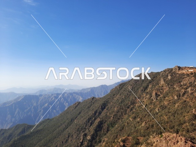 The herbs, trees, and green plants in the Asir region's Soudah Mountains, an aerial image of the mountainous environment, plateaus, and highlands, a view of the sky above the natural landscapes in Soudah Park, famous natural tourist spots and areas in the Kingdom of Saudi Arabia.