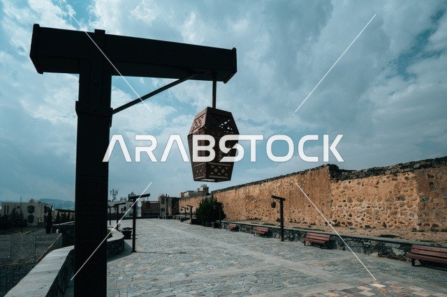 الفوانيس الخشبيه وأعمده الإنارة المتميزة حول القلعة الاثريه التاريخيه في منطقة عسير, الأماكن والمعالم السياحية المشهورة في مدينه أبها, البناء المشيد من الأحجار وجذوع أشجار العرعر, التصميم المعماري القديم للقلاع الحصينيه العسكرية في قرية شمسان