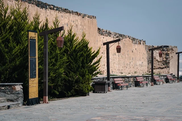 الفوانيس الخشبيه وأعمده الإنارة المتميزة حول القلعة الاثريه التاريخيه في منطقة عسير, الأماكن والمعالم السياحية المشهورة في مدينه أبها, البناء المشيد من الأحجار وجذوع أشجار العرعر, التصميم المعماري القديم للقلاع الحصينيه العسكرية في قرية شمسان