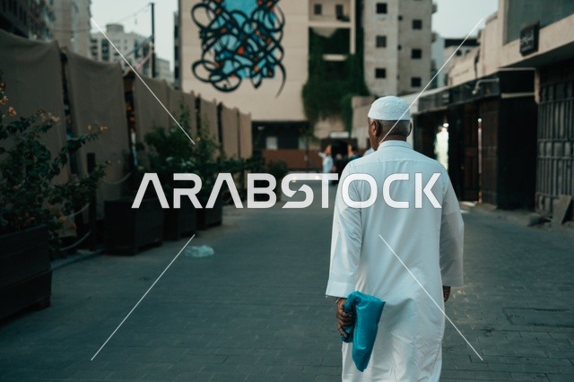 تجول المواطنين في الأحياء القديمة، المعالم التاريخية في جدة، المحلات التجارية في حواري البلد التاريخي في مدينة جدة في المملكة العربية السعودية ، التصميم المعماري العربي القديم للمباني الأثرية