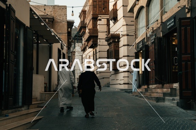 تجول المواطنين في الأحياء القديمة، المعالم التاريخية في جدة، المحلات التجارية في حواري البلد التاريخي في مدينة جدة في المملكة العربية السعودية ، التصميم المعماري العربي القديم للمباني الأثرية