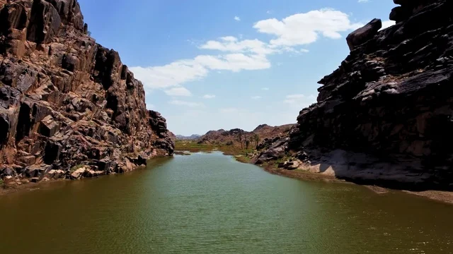 The course of Wadi Al-Masirq in Khyber Al-Janub, Asir region, the harsh mountainous nature, the peaks and highlands and the terrain, historical archaeological landmarks in the Kingdom of Saudi Arabia, natural background.