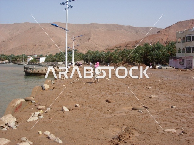 سيول مياه الامطار محافظة حقل في المملكة العربية السعودية ، صورة لتراكم الرمال والحجارة على الرصيف والجلسات البحرية في مدينة تبوك ، معالم تبوك , مناظر طبيعيه