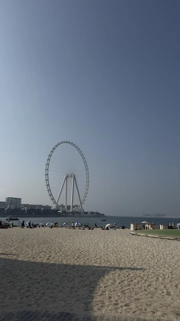 Progress, growth, and urban expansion, a picture of the Dubai Eye wheel among the buildings, the architectural engineering art of the facilities, Dubai's tourist landmarks, towers, and skyscrapers in the United Arab Emirates.