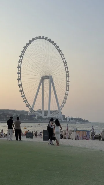 Progress, growth, and urban expansion, a picture of the Dubai Eye wheel among the buildings, the architectural engineering art of the facilities, Dubai's tourist landmarks, towers, and skyscrapers in the United Arab Emirates.