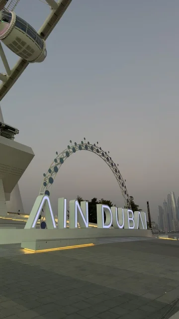 A picture of the Dubai Eye wheel among the buildings, progress, growth, and urban expansion, the architectural engineering art of the facilities, Dubai's tourist landmarks, towers, and skyscrapers in the United Arab Emirates.