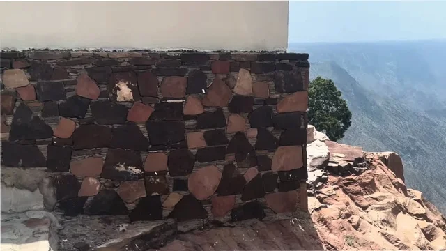 The peaks and mountain heights, a stone wall built in the traditional style on a deep valley, Al-Habla Park, famous tourist attractions in the Kingdom, buildings constructed from stones and tree trunks, the heritage architectural design of the village houses.