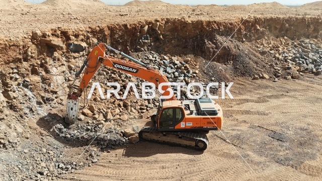 مفهوم الهندسة المعمارية والإنشاءات، جرافات ضخمة تعمل في الحفر ورفع الأنقاض والأتربة في موقع العمل، الاعتماد على الآلات والمعدات الثقيلة في أعمال البناء، مهنة ووظيفة هندسية صناعية في السعودية، تحسين البنية التحتية لإقامة المباني والمشاريع الحديثة في مدينة الرياض