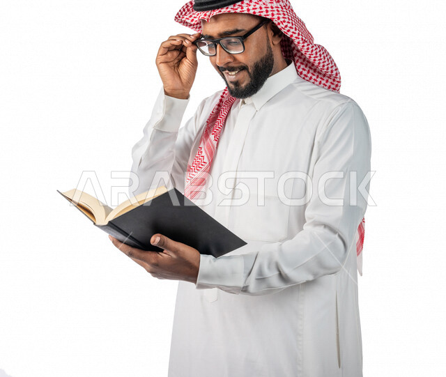 بورتريه لرجل خليجي سعودي مثقف ، بالزي السعودي ، يحمل بيده كتاب ، قراءة الكتب ، التعليم والدراسة ، مفهوم التحضير ومراجعة البحوث العلمية ، بيئة العمل ، مهن و وظائف ، مفهوم التثقف والتثقيف ، التعليم والثقافة ، قصص و روايات ، مفهوم إكتساب المعرفة ، باحث علمي