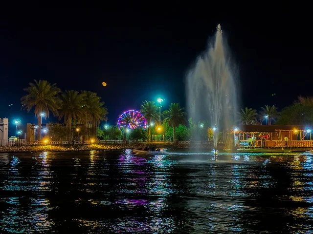 The lake of Al-Jawatha Park in the Al-Ahsa region at night, gardens and recreational parks, famous natural tourist attractions in the Kingdom of Saudi Arabia, attracting and drawing tourists from all over the world, interest in planting trees and green plants.