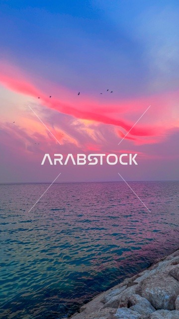 همسة الفجر الوردية في مدينة الخبر، ضوء الصباح الخفيف، تدرّجات وردية تتلألأ فوق البحر وتنعكس على المباني الساحلية، بداية يوم نابضة