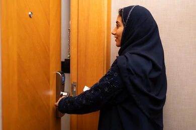 السياحه في المملكه العربيه السعوديه،  قفل متطور وحديث في فندق راقي، فتح الباب بالبطاقه الالكترونيه , الاستمتاع بالعطلات السياحيه والإجازه الصيفيه, امراه عربيه خليجيه سعودية محجبة ترتدي العباءة و الحجاب تقوم بفتح باب غرفة فندقية