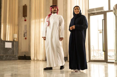 مفهوم الأسرة السعيدة، زوجان عربيان خليجيان سعوديان سائحان يرتديان الزي التقليدي يمشيان ويتجولان في بهو الفندق السياحي، قضاء أجمل الأوقات في أفضل الفنادق الخليجية ، رحلة زوجية ممتعة ، أجواء عائلية مرحة ، عطلة نهاية الأسبوع