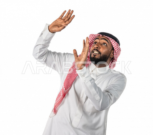 بورتريه لرجل عربي خليجي سعودي ، يرتدي الزي السعودي التقليدي ، بإيماءات وجه ويدين مختلفة تدل على الخوف والرعب ، خلفية بيضاء ، مفهوم الذعر ، الرهبة والخوف من شيء ، حركة اليدين تدل على الابتعاد والتصدي لشيء ما