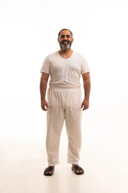 مفهوم لغة الجسد، ملابس داخلية رجالية مريحة باللون الابيض، إيماءات السعادة والسرور، الوقوف باستقامة والنظر إلى الكاميرا، أزياء عربية سعودية، بورتريه لرجل عربي خليجي سعودي وسيم يرتدي سروال وفنيله بيضاء ينظر بفرح، صورة لكامل الجسم، خلفية بيضاء