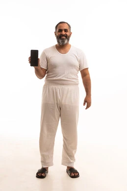 عرض شاشة سوداء فارغه عبر الجوال، بورتريه لرجل عربي خليجي سعودي يرتدي سروال وفنيله بيضاء يحمل الهاتف المحمول، تطور التكنولوجيا والأجهزة التقنية، صورة الجسم بالطول الكامل، خلفية بيضاء