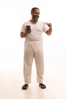 إمكانية الدفع الإلكتروني عبر التقنيات الحديثة المتطورة، استخدام تطبيقات الجوال للدفع والشراء، بورتريه لرجل عربي خليجي سعودي يرتدي سروال وفنيله يمسك بيده البطاقة الإلكترونية والهاتف المحمول، الجسم بالطول الكامل، خلفية بيضاء