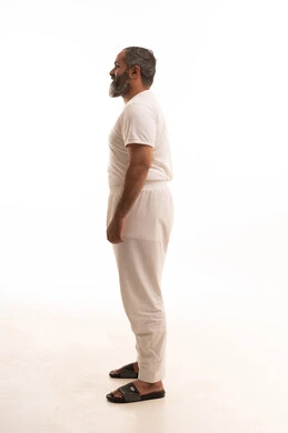 Comfortable men's underwear in white, gestures of happiness and joy, standing upright, Saudi Arabian fashion, the concept of body language, a side portrait of a handsome Arab Gulf Saudi man wearing white pants and a shirt looking confidently, a full-body image, white background.