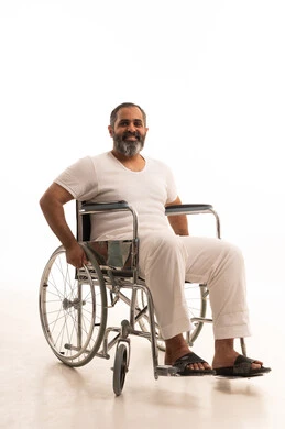 The lifestyle of people with determination, using wheelchairs to assist with movement and mobility, improving the quality of life for those with physical disabilities, a portrait of an Arab Saudi Gulf man wearing pants and a white t-shirt sitting in a wheelchair looking at the camera with expressions of happiness, white background.