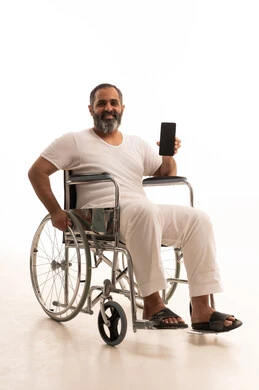 عرض شاشة سوداء فارغه عبر الجوال، استخدام جهاز تقني حديث،بورتريه لرجل عربي سعودي خليجي يرتدي سروال وفانيلا أبيض يجلس على كرسي متحرك يمسك الهاتف المحمول، خلفية بيضاء