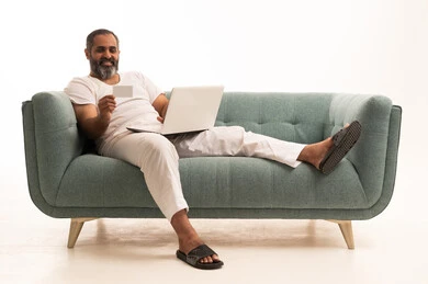 الدفع الالكتروني عبر الانترنت، النظر إلى الكاميرا بإيماءات السرور باستخدام الوسائل الحديثة، بورتريه لرجل عربي سعودي خليجي يرتدي سروال وفانيلا أبيض يجلس على الاريكة يمسك بيده اللابتوب وبطاقة الإئتمان البنكية، خلفية بيضاء الدفع الالكتروني عبر الانترنت، النظر إلى الكاميرا بإيماءات السرور باستخدام الوسائل الحديثة، بورتريه لرجل عربي سعودي خليجي يرتدي سروال وفانيلا أبيض يجلس على الاريكة يمسك بيده اللابتوب وبطاقة الإئتمان البنكية، خلفية بيضاء